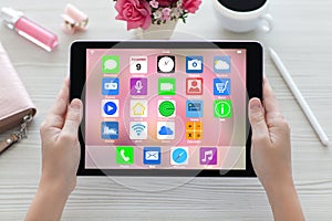 Woman hands holding tablet computer with home screen icons apps
