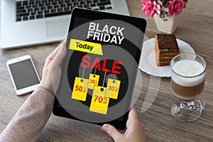 Woman hands holding tablet computer with sale black friday scree