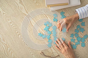 Woman hands holding two puzzle piece jigsaw connected match solution problem concept closeup