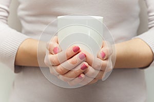 Woman hands holding white cup of tea or coffe