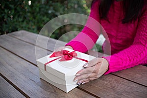 Woman hands holding white gift box