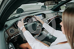 Woman hands keeping steering wheel in car