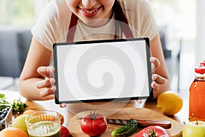 Woman hands at kitchen showing tablet with empty blank screen mockup