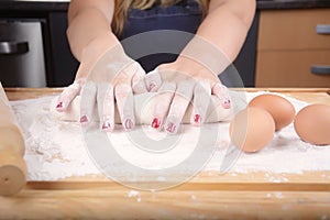 Woman hands kneading dough.