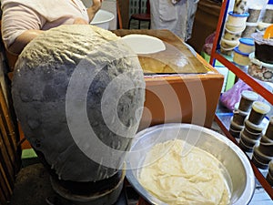Woman hands kneading dough on an oily table cooking traditional rghayf or msemen, a traditional moroccan bread in Fes medina