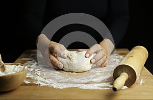 Woman hands kneading fresh dough for making bread or pizza.