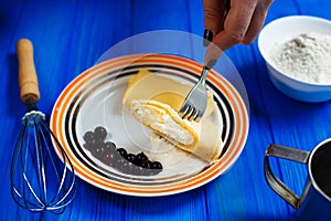 Woman hands with knife and fork cutting and dipping into sour cr