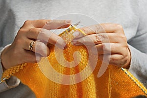 Woman hands with knitting needles and wool yarn. Needlework concept