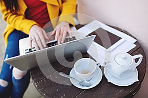 Woman hands with laptop tablet and tea outdoors in cafe