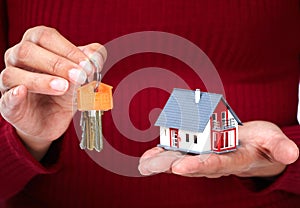 Woman Hands with little house and key.