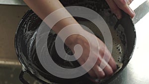 Woman hands after lunch, sponges, dirty black pan metal table, kitchen, summer cottage