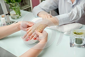 Woman hands in a nail salon receiving a  hand massage by a beautician. SPA manicure