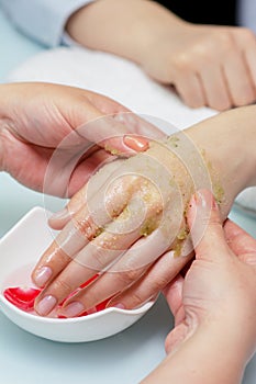 Woman hands in a nail salon receiving a  hand massage by a beautician. SPA manicure