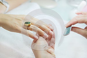 Woman hands in a nail salon receiving a manicure by a beautician