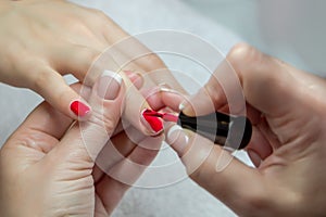 Woman hands in a nail salon receiving a manicure by a beautician