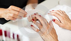 Woman hands in nail salon receiving manicure. Nail filing