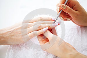 Woman hands in a nail salon receiving a manicure procedure. SPA