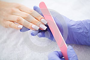 Woman hands in a nail salon receiving a manicure procedure. SPA