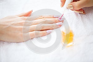 Woman hands in a nail salon receiving a manicure procedure. SPA