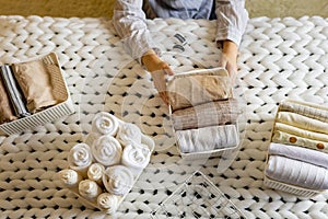 Woman hands neatly folded linens and towels use Marie Kondo method with sticky label tags