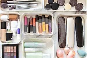 Woman hands neatly placing cosmetic and vanity items in MUJI's PP makeup storage boxes.