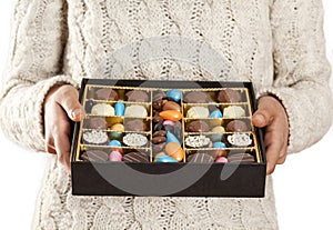 Woman hands offering chocolates in box
