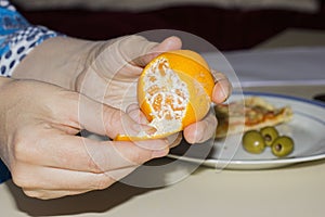 Woman hands opening tangerine photo