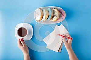 Woman hands painting heart with tea and donuts