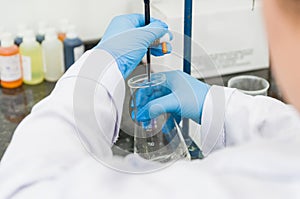 Woman hands performing titration test on chemical quality contro photo