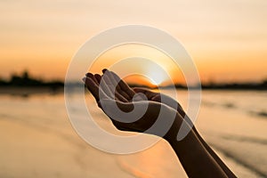 Woman hands place together like praying in front of nature green  background