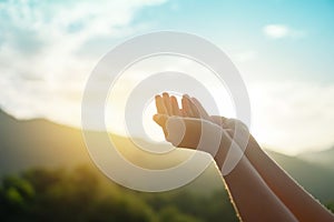 Woman hands place together like praying in front of nature green  background