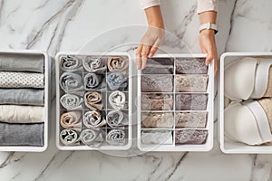 Woman hands placing organizer drawer divider with full of folded underwears and socks.