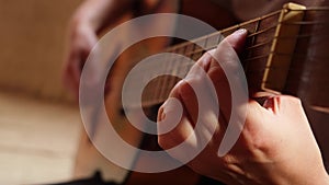 Woman hands playing classical acoustic guitar, closeup. Music concept. Girl learning to play song and writing music