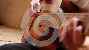 Woman hands playing classical acoustic guitar, closeup. Music concept. Girl learning to play song and writing music