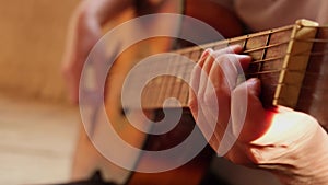 Woman hands playing classical acoustic guitar, closeup. Music concept. Girl learning to play song and writing music