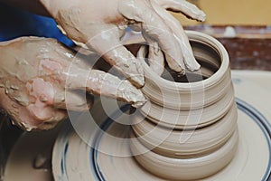 Woman hands on pottery wheel. Craftsman artist shapes pot photo