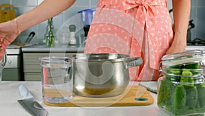 Woman hands pouring water in saucepan measuring jug to cook boil food, dish.