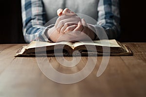 Woman hands praying with a bible