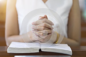 Woman hands praying on a holy bible in church for faith concept, Spirituality and Christian religion