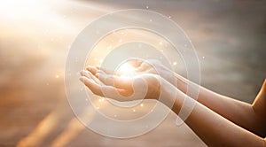 Woman hands praying on sunset background