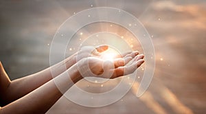 Woman hands praying for on sunset background