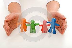 Woman hands protecting clay people family