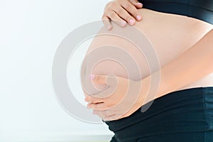Woman hands protecting pregnant belly isolated against white background