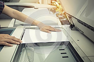 Woman hands putting a sheet of paper into a copying device