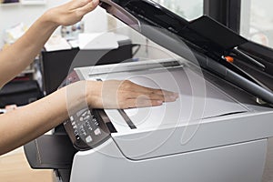 Woman hands putting a sheet of paper into a copying device