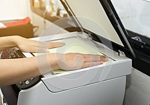 Woman hands putting a sheet of paper into a copying device