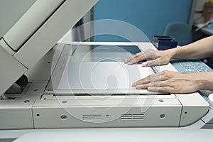 Woman hands putting a sheet of paper into a copying device