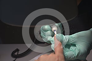 Woman hands receiving a manicure in beauty salon. Nail filing. Close up, selective focus