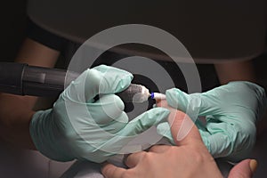 Woman hands receiving a manicure in beauty salon. Nail filing. Close up, selective focus