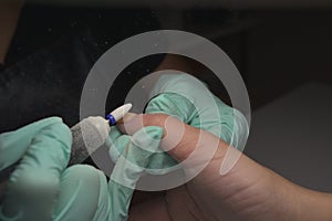 Woman hands receiving a manicure in beauty salon. Nail filing. Close up, selective focus